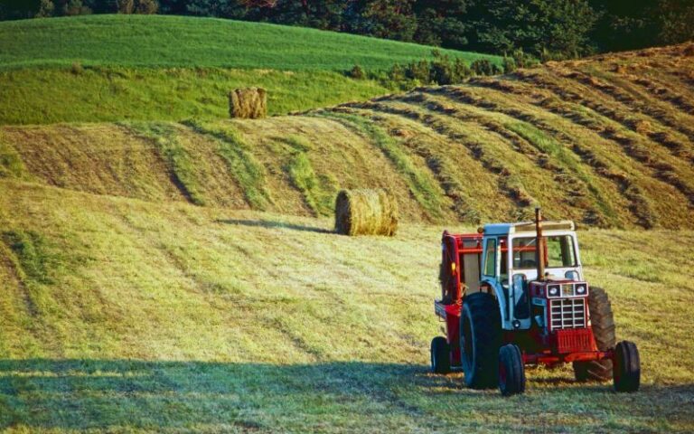 Tractor operating on an Ontario farm field with agricultural equipment and crops protected by farm insurance